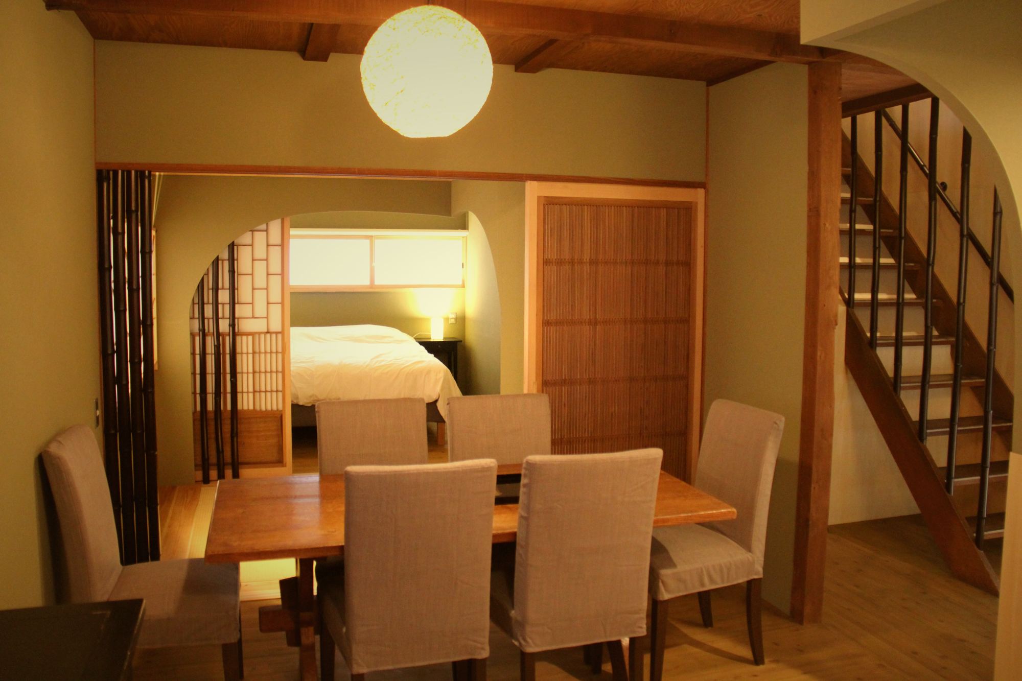 Dining table for eight at Enso-an, with the ground-floor bedroom seen through a shoji arch