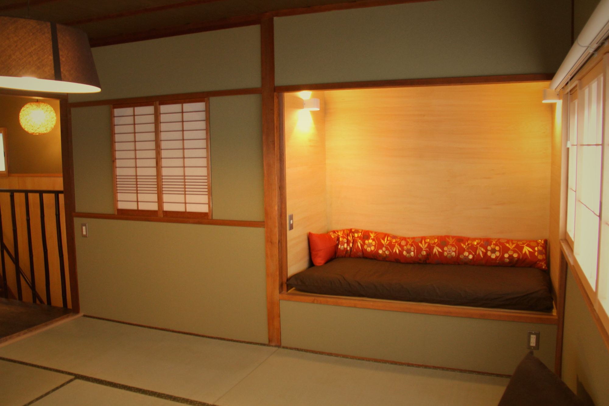Tatami room with shoji windows and a cushioned alcove bench at Enso-an